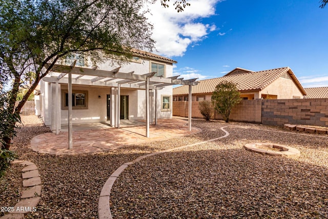 back of property with a patio, a pergola, and a fire pit