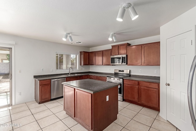 kitchen with appliances with stainless steel finishes, a center island, sink, and light tile patterned floors