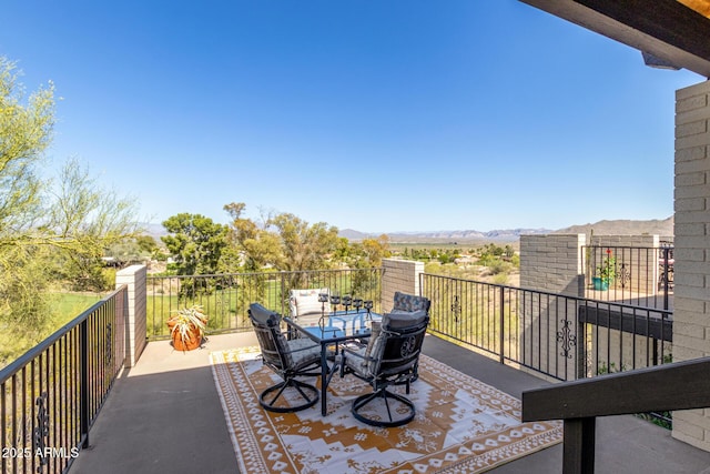 view of patio / terrace with a mountain view, outdoor dining area, and a balcony
