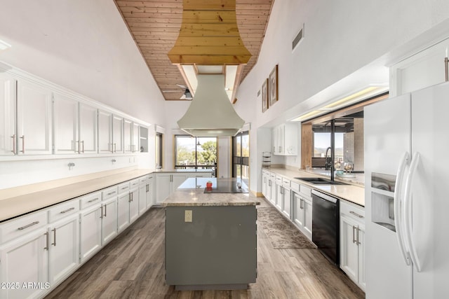kitchen featuring wood ceiling, a sink, a center island, black appliances, and high vaulted ceiling