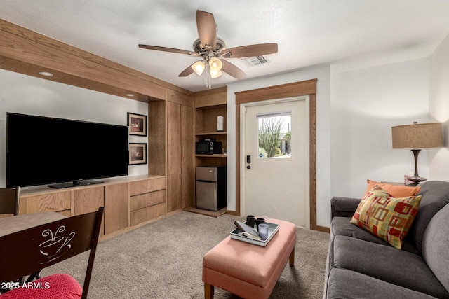 living area with visible vents, ceiling fan, and light colored carpet
