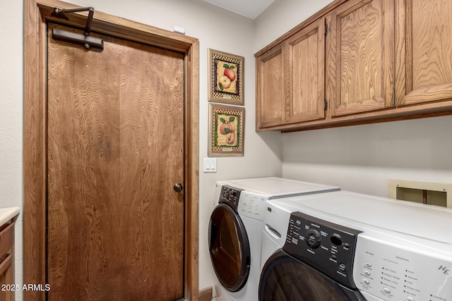 laundry area with separate washer and dryer and cabinet space