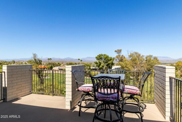 balcony featuring a mountain view and outdoor dining area