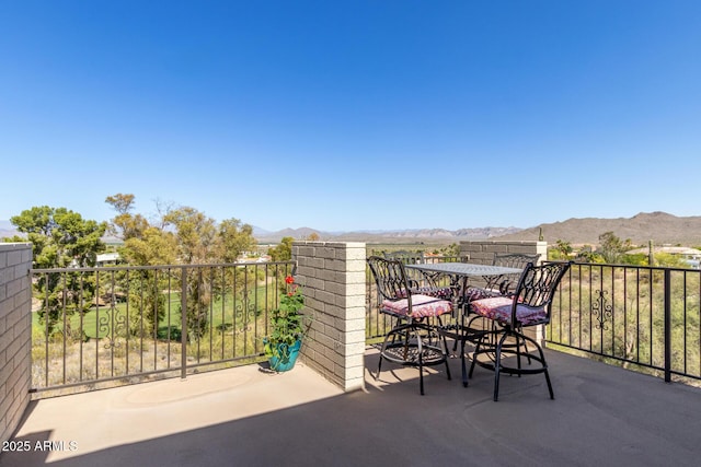 view of patio / terrace with a mountain view, outdoor dining area, and a balcony