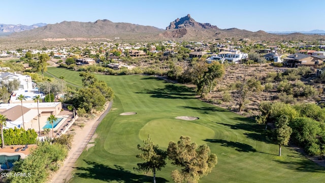 drone / aerial view featuring golf course view, a mountain view, and a residential view