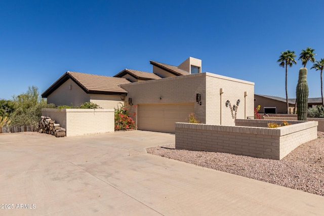 view of front of property featuring driveway, a garage, and brick siding