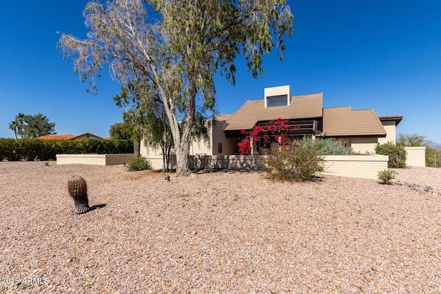 southwest-style home with fence and a tile roof