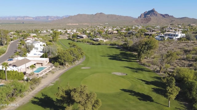 drone / aerial view with a residential view, a mountain view, and golf course view