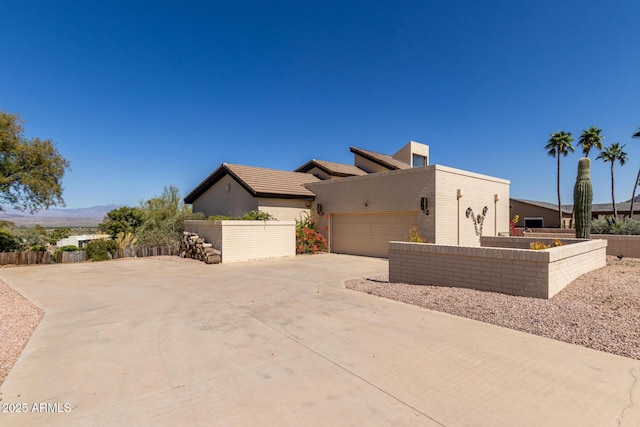 view of home's exterior with fence, concrete driveway, and a garage