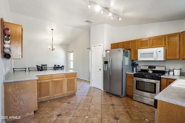 3501 Camino Bella Rosa, Sierra Vista, AZ 85650 - kitchen featuring appliances with stainless steel finishes, light countertops, brown cabinetry, vaulted ceiling, and visible vents