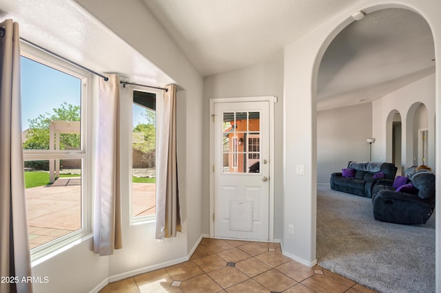 3501 Camino Bella Rosa, Sierra Vista, AZ 85650 - doorway featuring baseboards, arched walkways, lofted ceiling, and light tile patterned floors