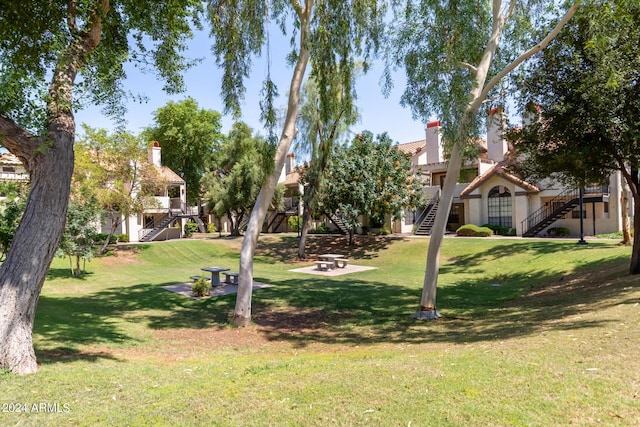 view of home's community with a fire pit and a lawn