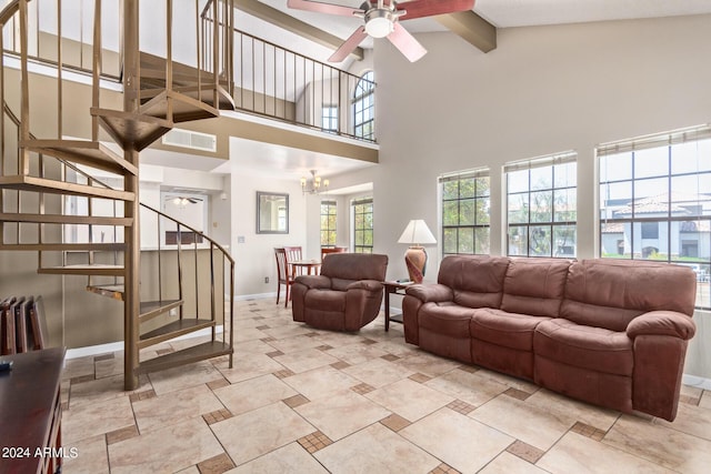 living room featuring beam ceiling, plenty of natural light, ceiling fan with notable chandelier, and a high ceiling