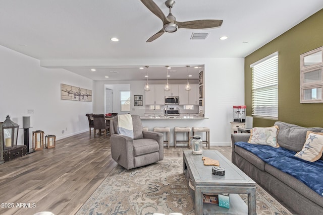 19415 W College Dr, Litchfield Park, AZ 85340 - living room with light wood-style flooring, a ceiling fan, recessed lighting, and baseboards