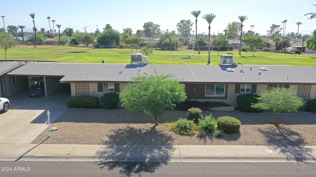 view of front of property with central air condition unit, a carport, driveway, and a front lawn