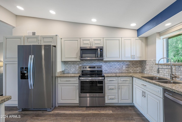 kitchen featuring visible vents, appliances with stainless steel finishes, a sink, lofted ceiling, and decorative backsplash
