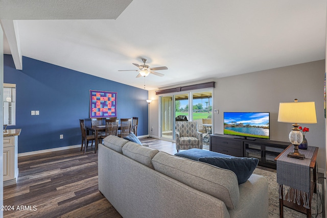 living room featuring ceiling fan, dark hardwood / wood-style floors, and lofted ceiling with beams