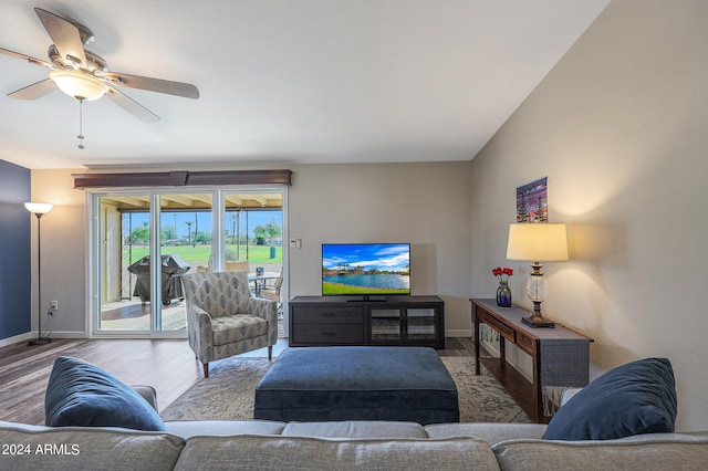 living room featuring ceiling fan, baseboards, and wood finished floors