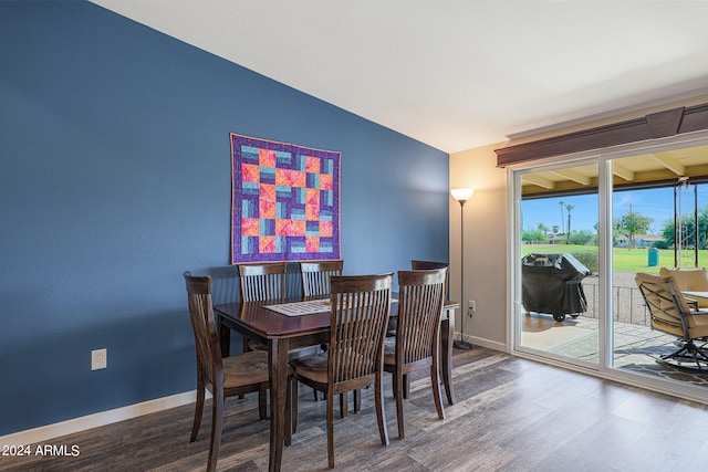 dining space featuring wood-type flooring and vaulted ceiling