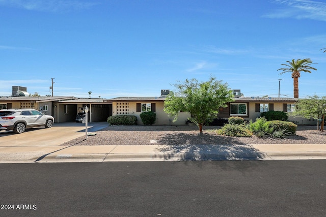 single story home with a carport, driveway, and central air condition unit