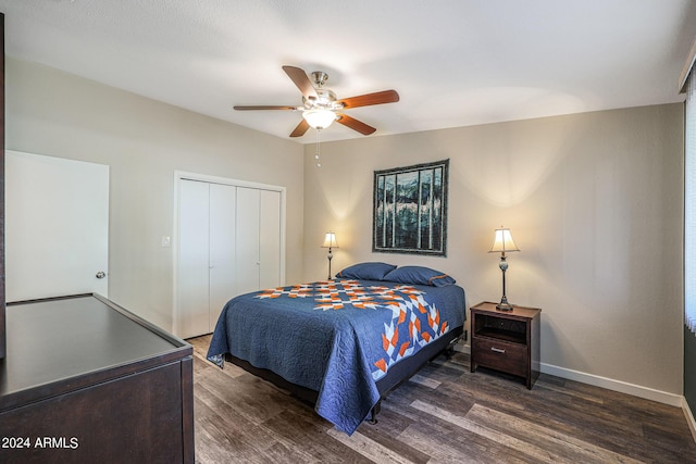 bedroom with dark wood-type flooring, a closet, baseboards, and a ceiling fan