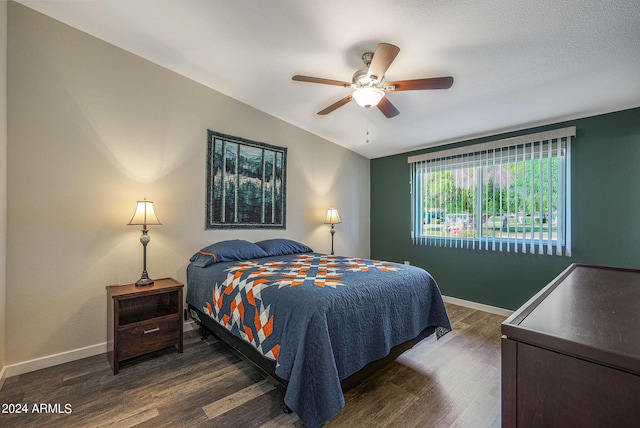 bedroom featuring baseboards, ceiling fan, and dark wood-style floors