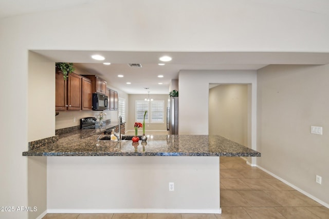 kitchen with visible vents, brown cabinetry, range with electric cooktop, black microwave, and a peninsula