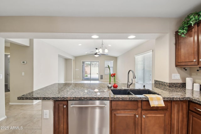 kitchen featuring light tile patterned floors, a peninsula, a sink, dishwasher, and dark stone countertops