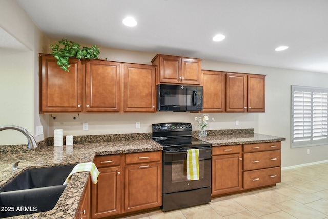 kitchen featuring black appliances, brown cabinetry, a sink, and recessed lighting