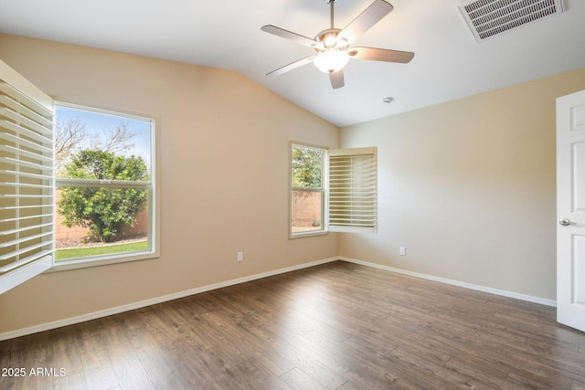 unfurnished room featuring baseboards, visible vents, vaulted ceiling, and wood finished floors