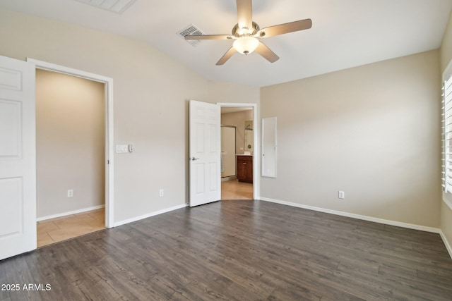 unfurnished bedroom featuring ensuite bath, baseboards, ceiling fan, and dark wood-type flooring