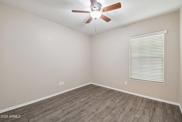 spare room with wood finished floors, a ceiling fan, and baseboards