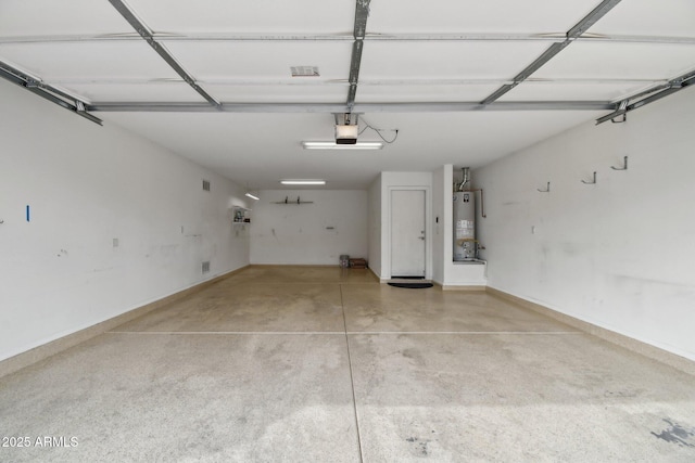 garage featuring baseboards, gas water heater, and a garage door opener