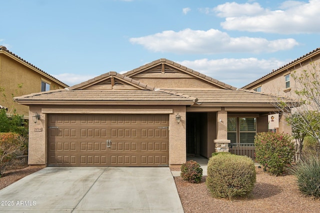 view of front of property featuring a garage, stucco siding, driveway, and a tiled roof