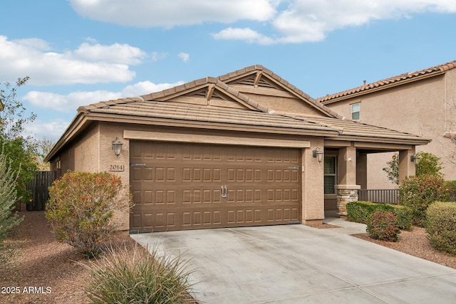 view of front of property with a garage, driveway, a tile roof, and stucco siding