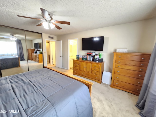 carpeted bedroom featuring ensuite bathroom, ceiling fan, a closet, and a textured ceiling