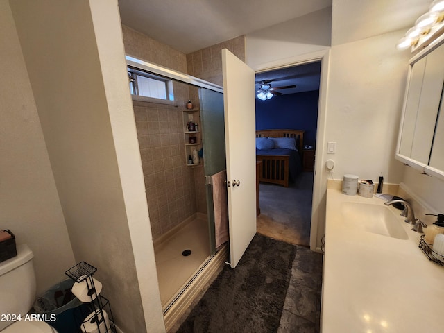 bathroom with ceiling fan, a shower with door, vanity, and toilet