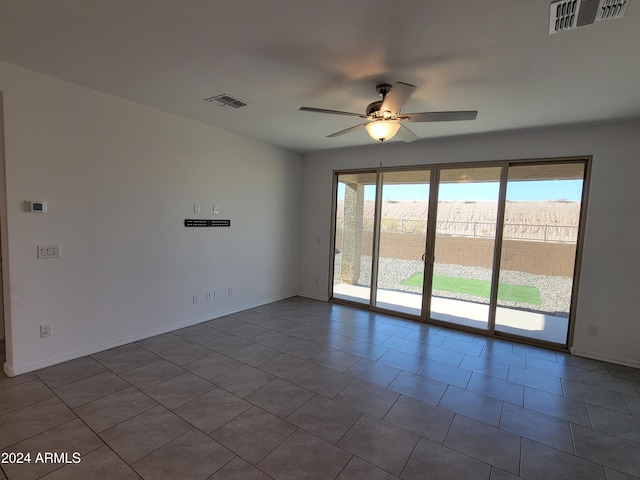 tiled empty room featuring ceiling fan