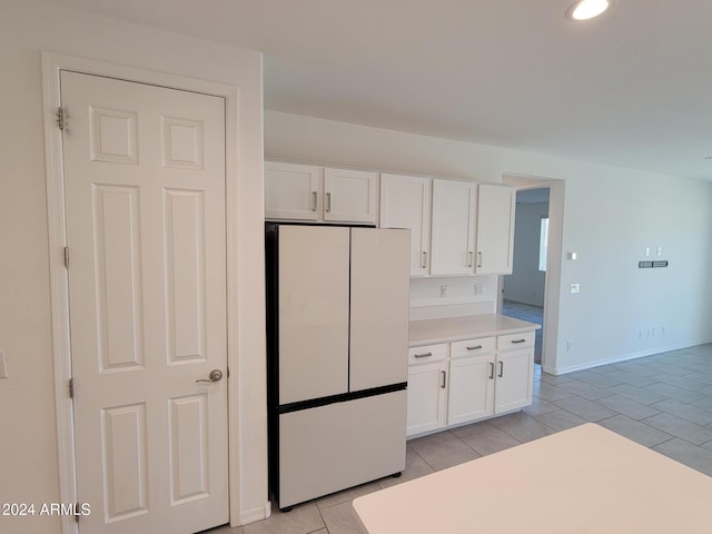 kitchen featuring white cabinetry, light tile patterned floors, and white refrigerator