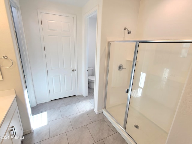 bathroom with toilet, vanity, tile patterned floors, and an enclosed shower