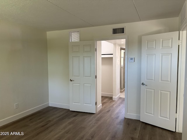 unfurnished bedroom featuring dark hardwood / wood-style flooring