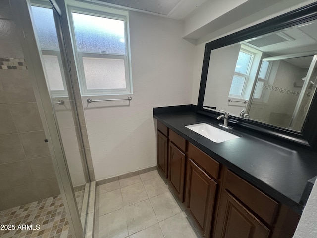 bathroom with tile patterned floors, vanity, and a tile shower