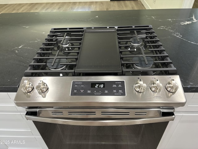 interior details with white cabinetry and stainless steel stove