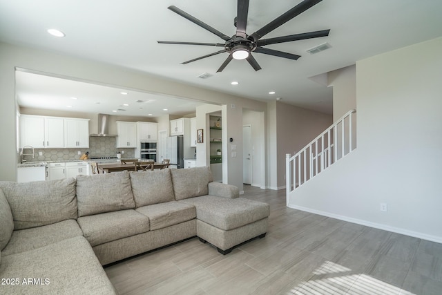 living room featuring ceiling fan and sink