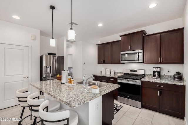 3670 E Sandoval Dr, San Tan Valley, AZ 85140 - kitchen with a sink, a breakfast bar area, appliances with stainless steel finishes, visible vents, and dark brown cabinets