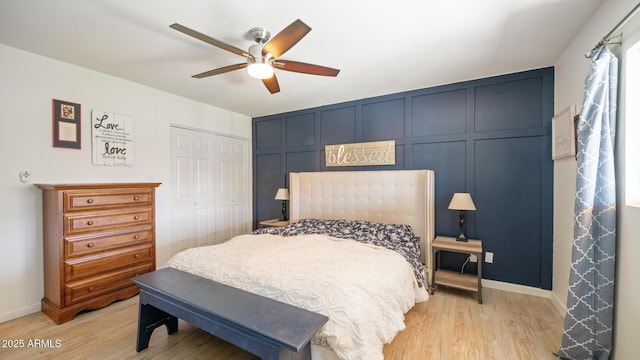 bedroom with light hardwood / wood-style flooring, ceiling fan, and a closet