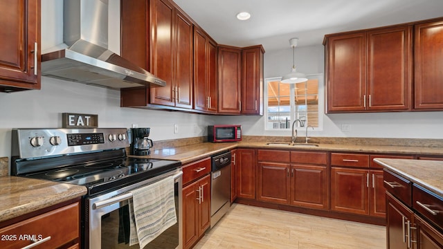 kitchen with appliances with stainless steel finishes, pendant lighting, sink, light stone counters, and wall chimney exhaust hood