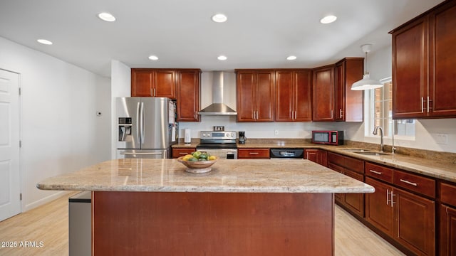 kitchen with sink, stainless steel appliances, light stone countertops, a kitchen island, and wall chimney exhaust hood