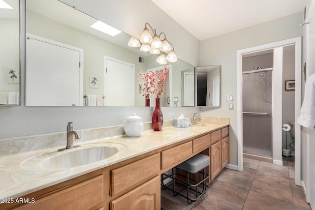 bathroom with a skylight, vanity, tile patterned floors, and a shower with shower door