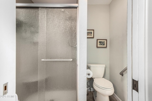 bathroom featuring an enclosed shower and toilet